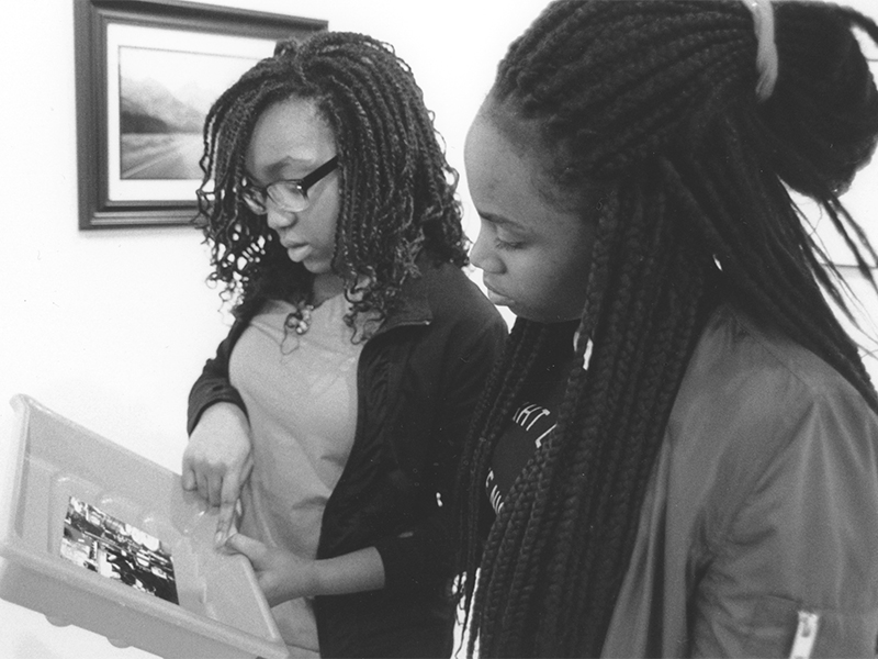 Two students examining their photograph from the darkroom